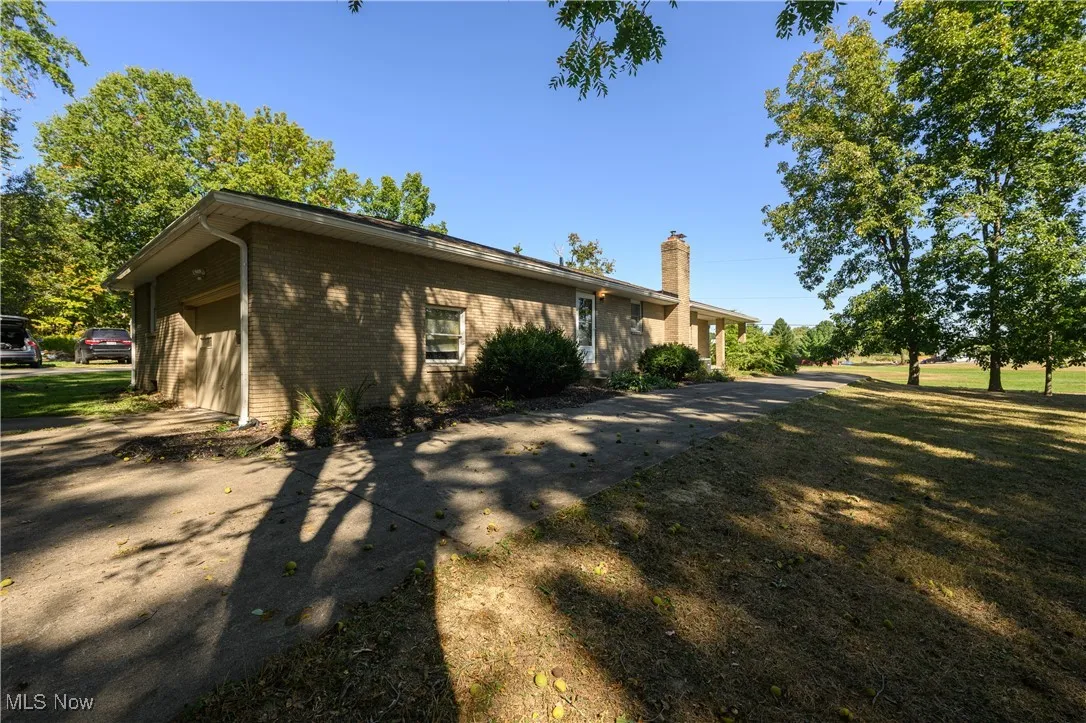 Back of house with brick siding and a chimney