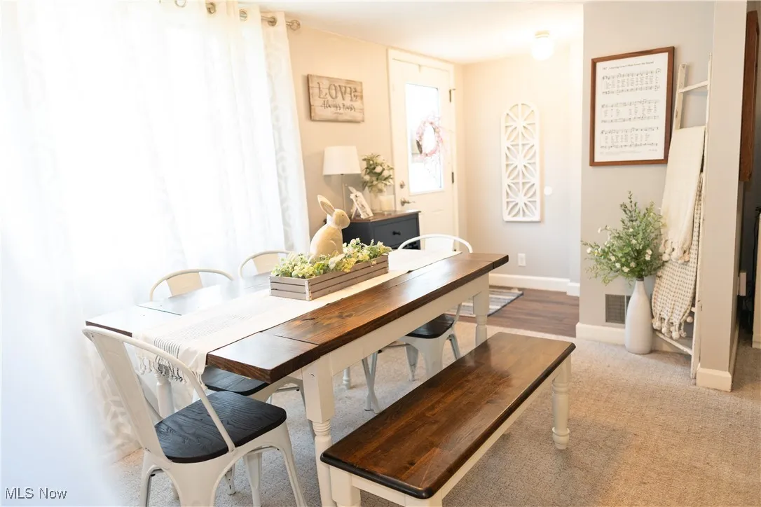Dining space featuring baseboards and carpet