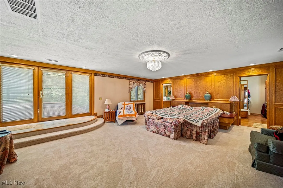Bedroom featuring carpet floors, a textured ceiling, and a chandelier