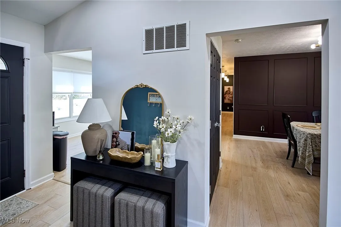 Hallway featuring light wood finished floors and baseboards