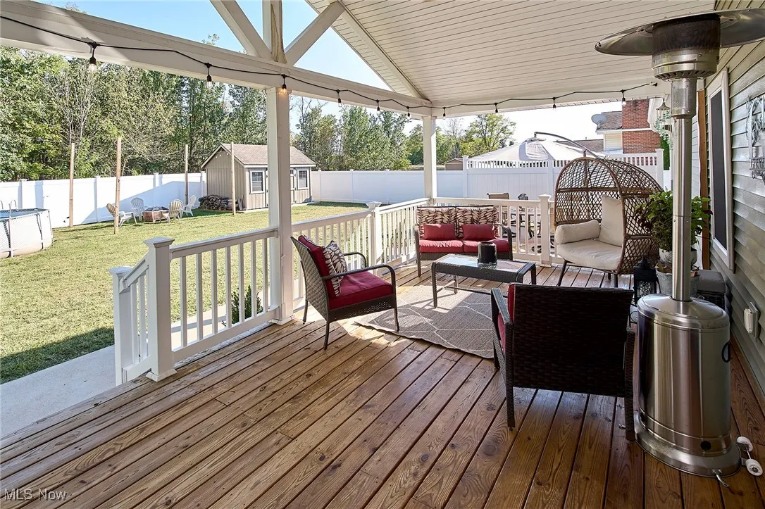 Deck featuring an outdoor living space, a storage shed, and a fenced backyard