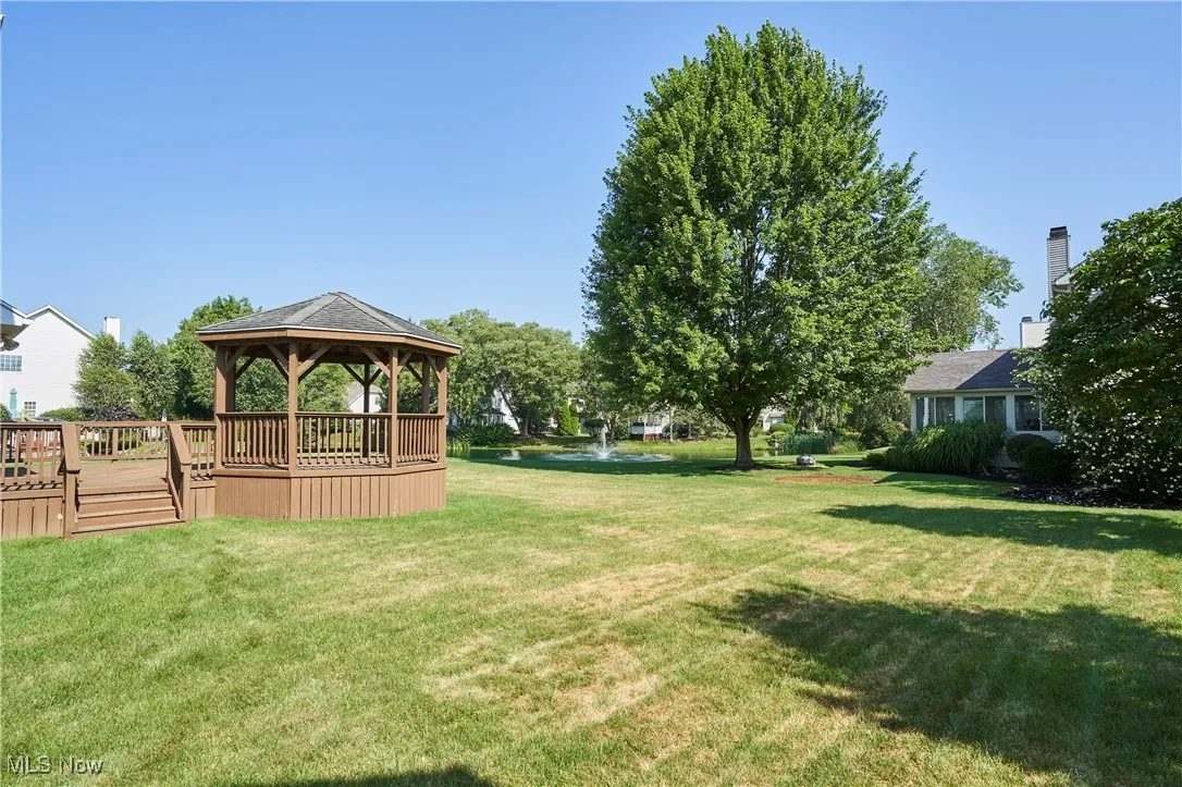 View of green lawn featuring a gazebo and a deck