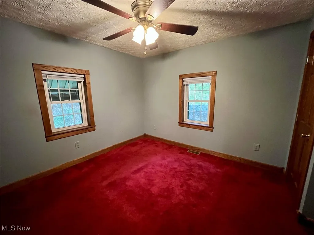 Bedroom featuring carpet, a textured ceiling, and ceiling fan