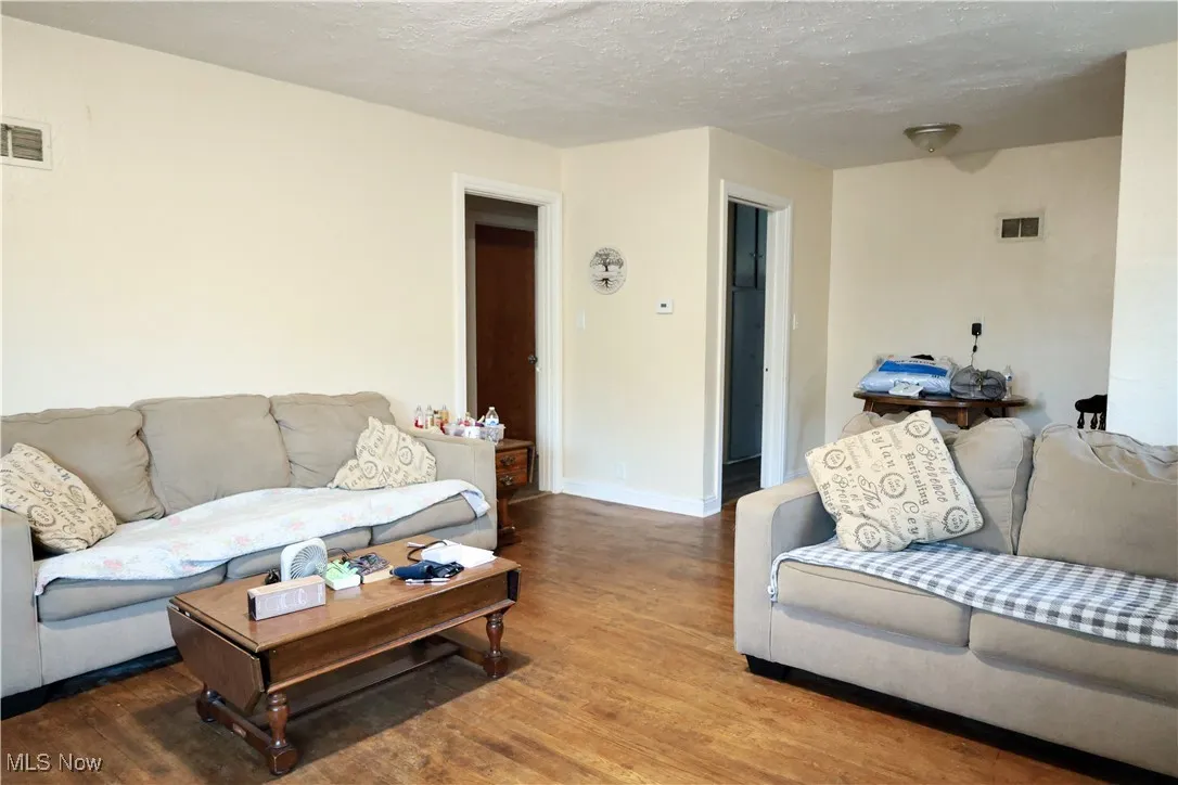 Living area featuring wood finished floors and a textured ceiling