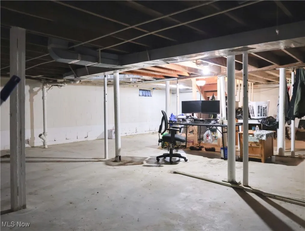Unfinished below grade area featuring a desk
