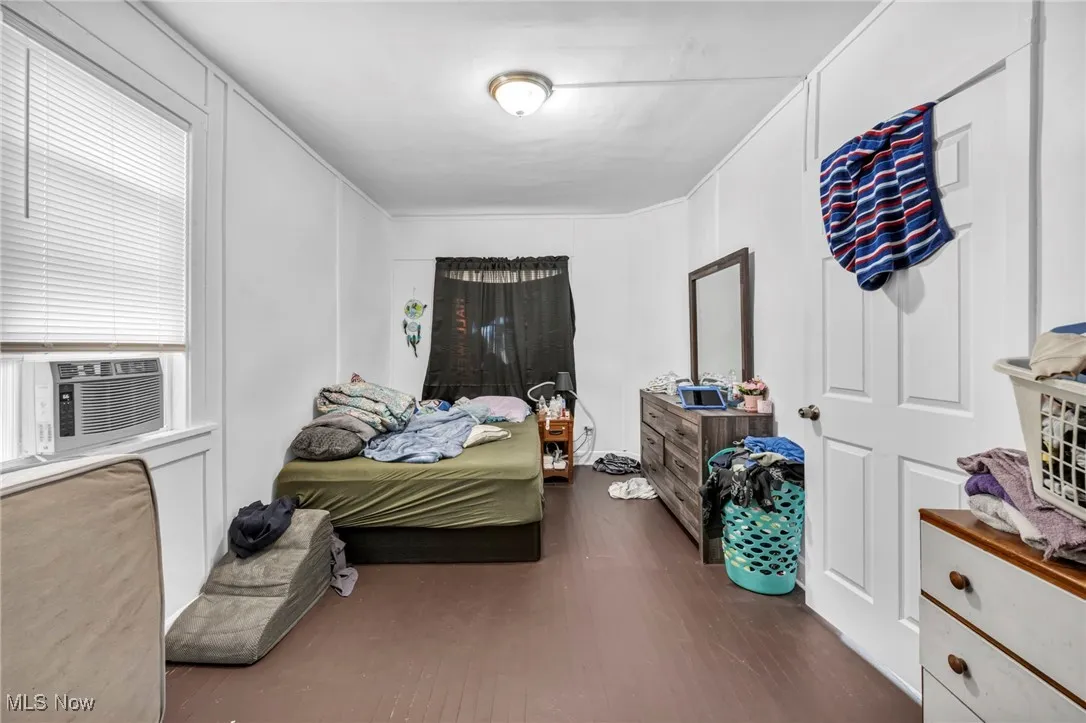 Bedroom with dark wood-style floors and cooling unit