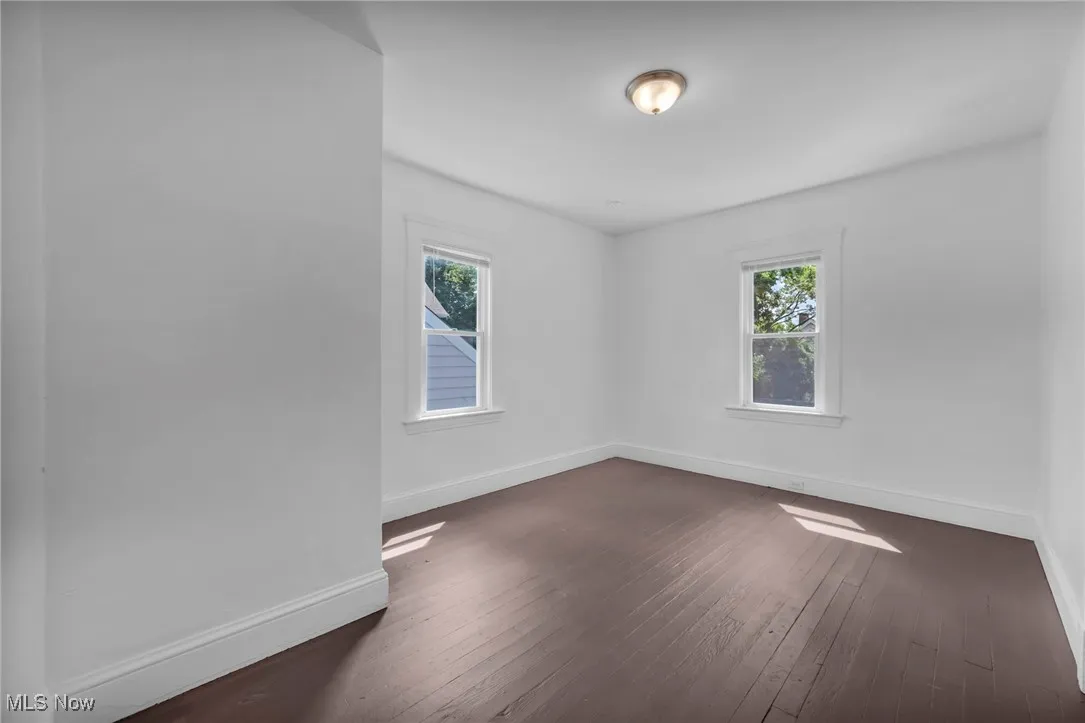 Spare room with dark wood finished floors and plenty of natural light