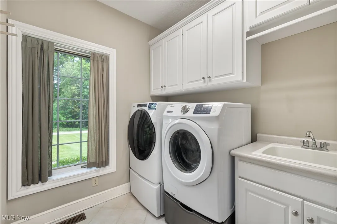 Washroom with washer and dryer, cabinet space, off of kitchen
