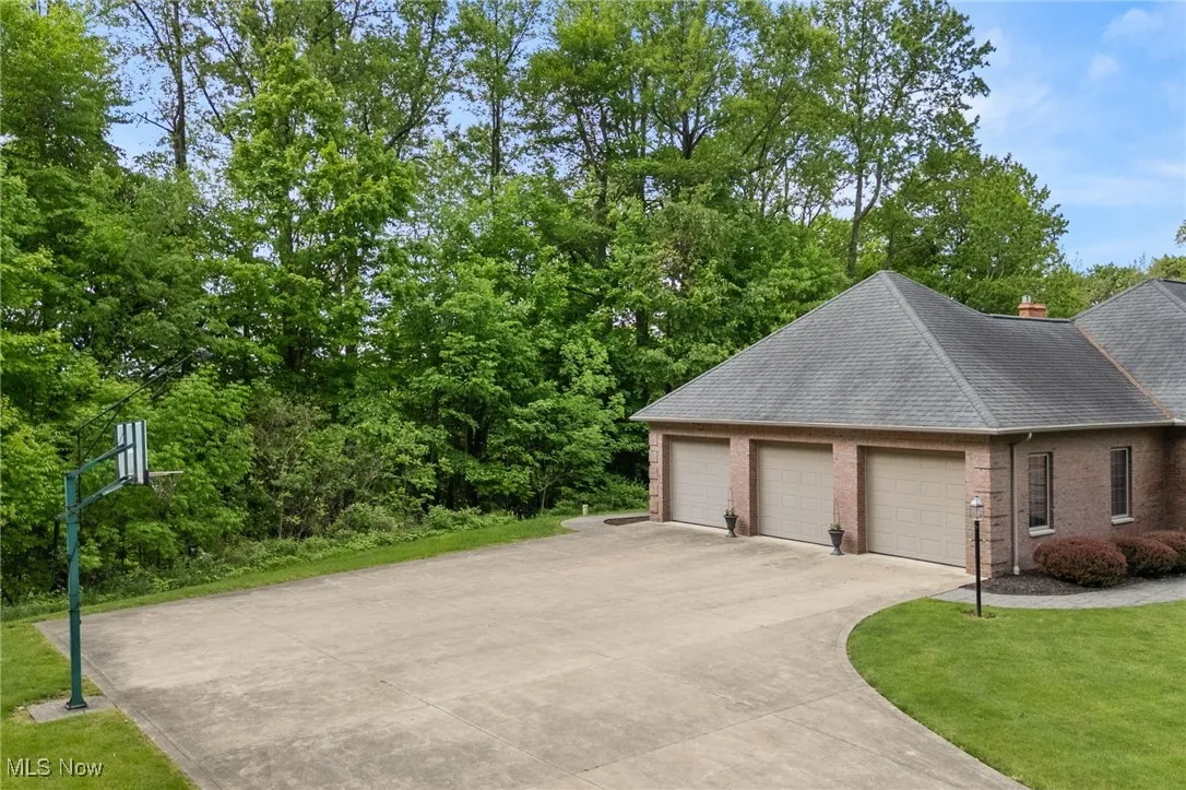 Garage with driveway and view of scattered trees