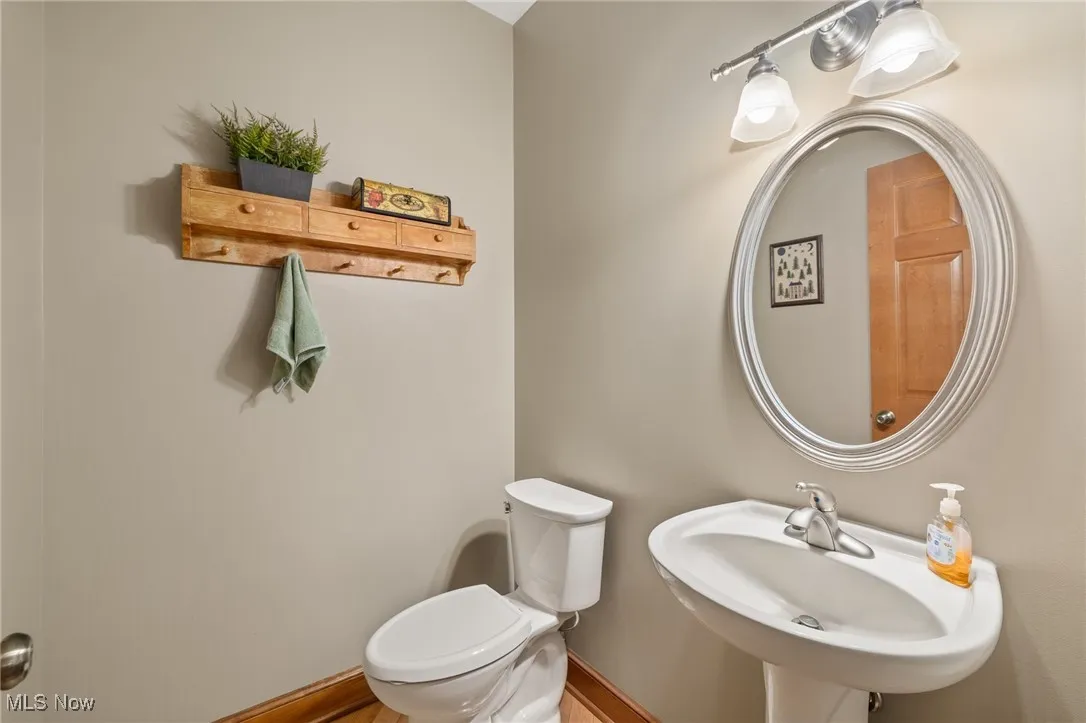 Bathroom featuring toilet and baseboards. 1/2 bath off of kitchen