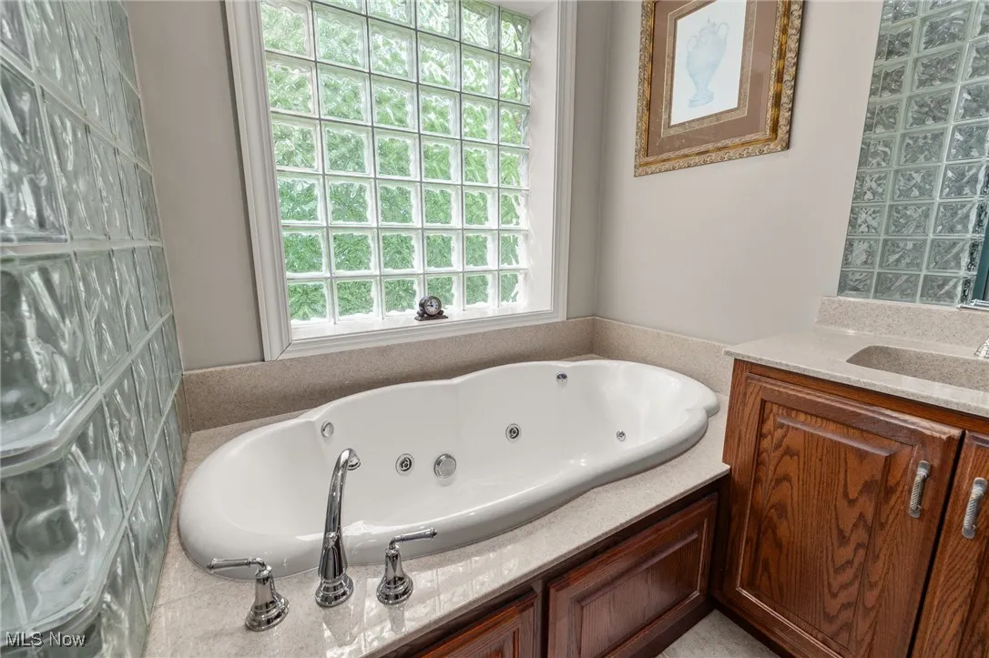 Bathroom featuring a jetted tub and vanity