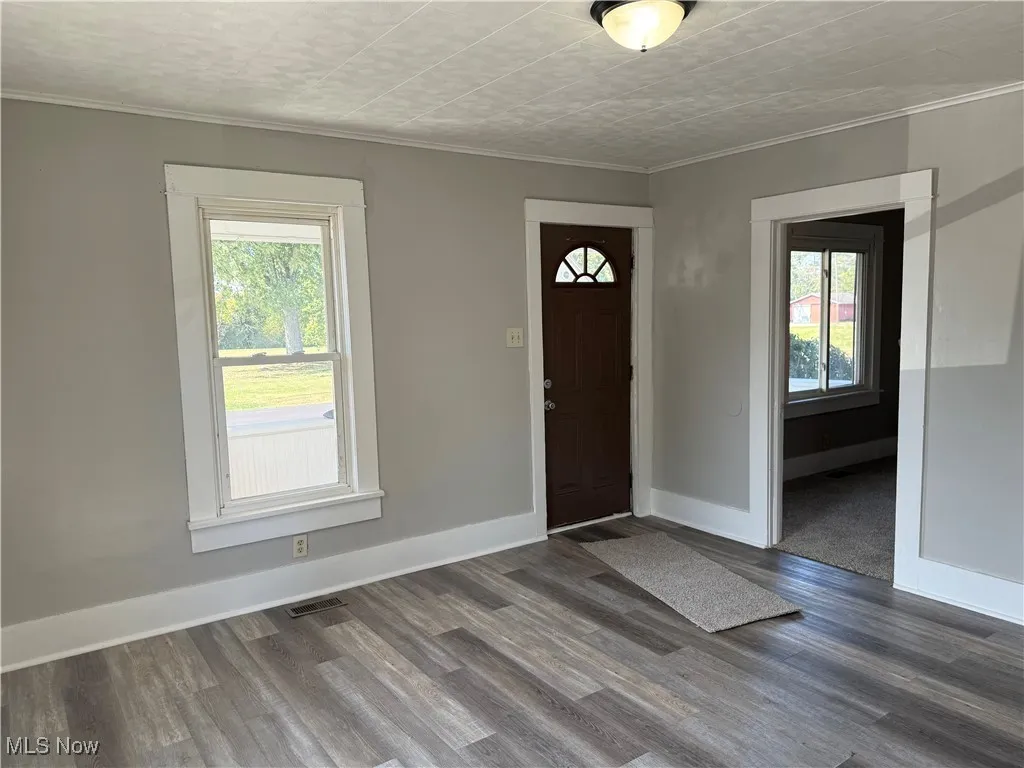 Entrance foyer featuring ornamental molding and wood finished floors