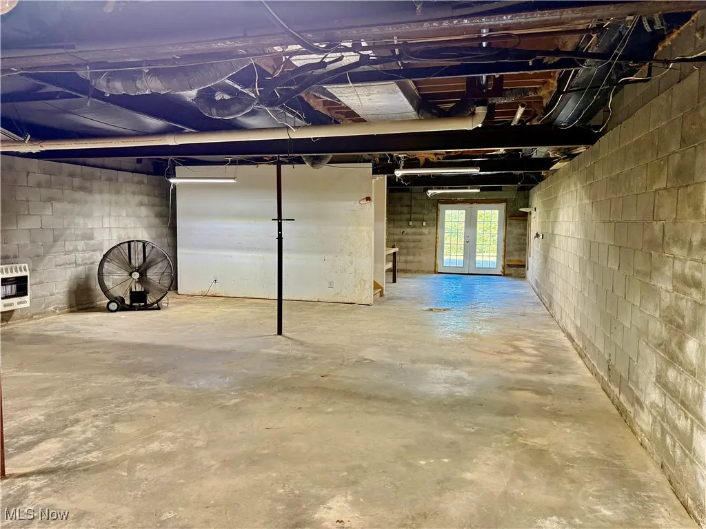 Large basement with French doors leading out to patio area.