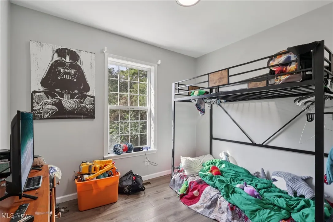 Bedroom with wood finished floors and baseboards