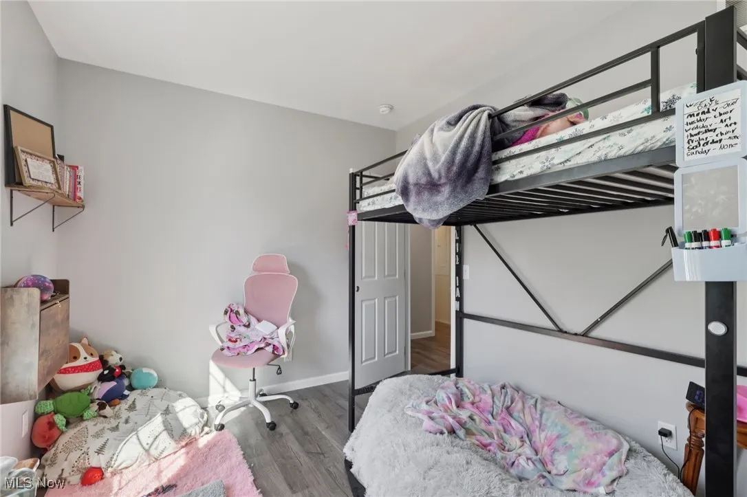 Bedroom featuring wood finished floors and baseboards