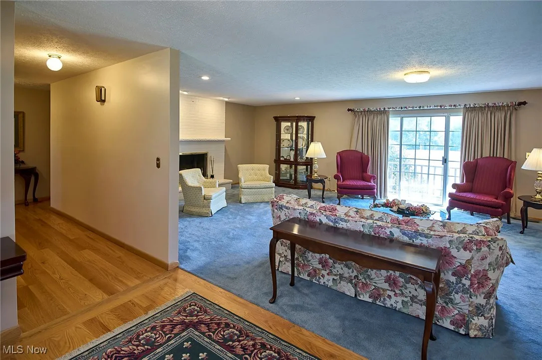 Living area featuring a textured ceiling, wood finished floors, a fireplace, and recessed lighting
