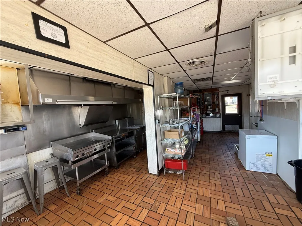 Kitchen featuring a drop ceiling and white fridge