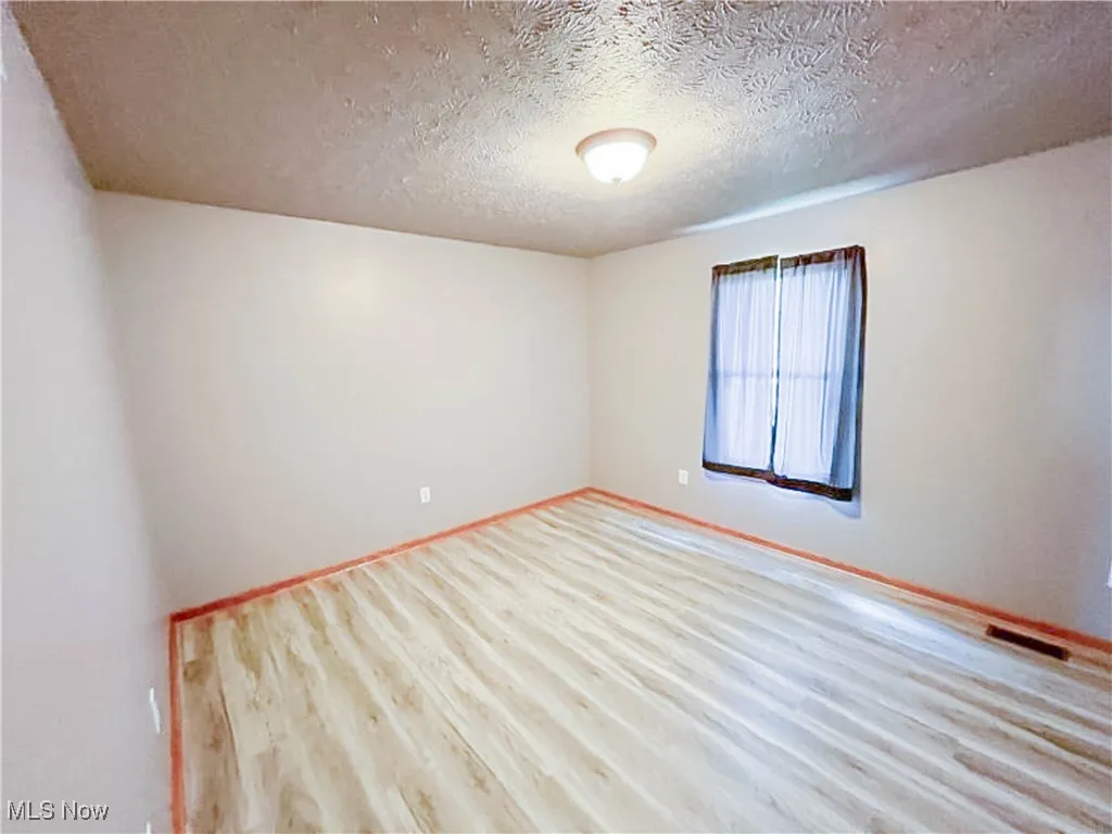 Bedroom with laminate floors and a textured ceiling