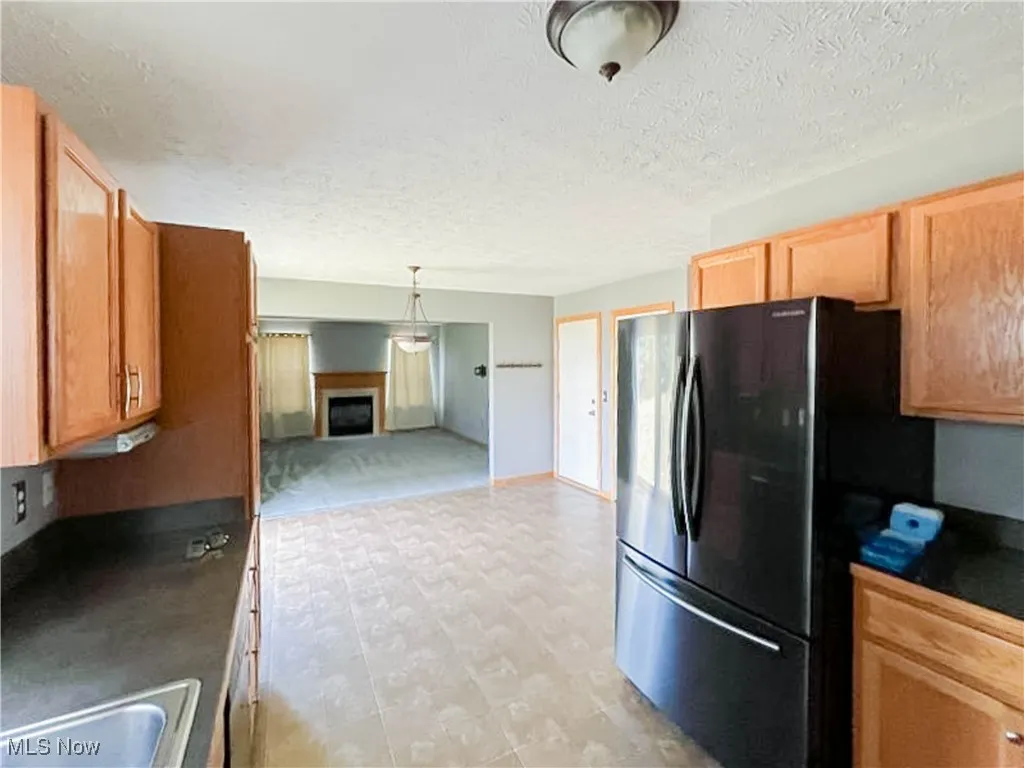 Kitchen with open floor plan, dark countertops, a textured ceiling