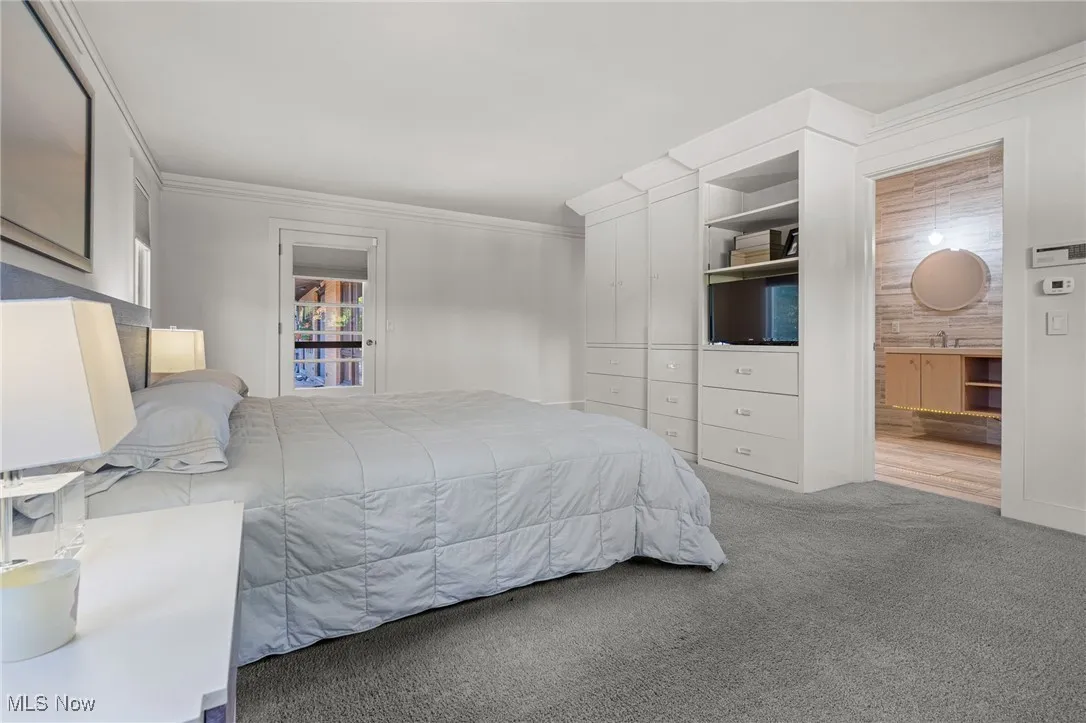 Bedroom with ornamental molding and carpet