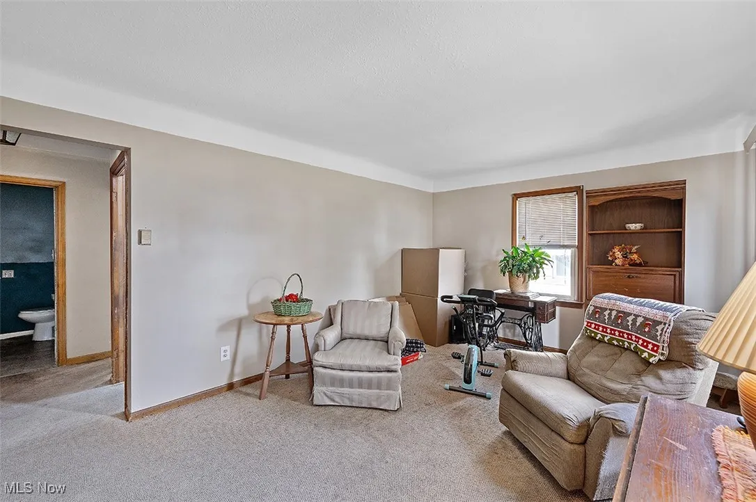 Sitting room featuring carpet and baseboards
