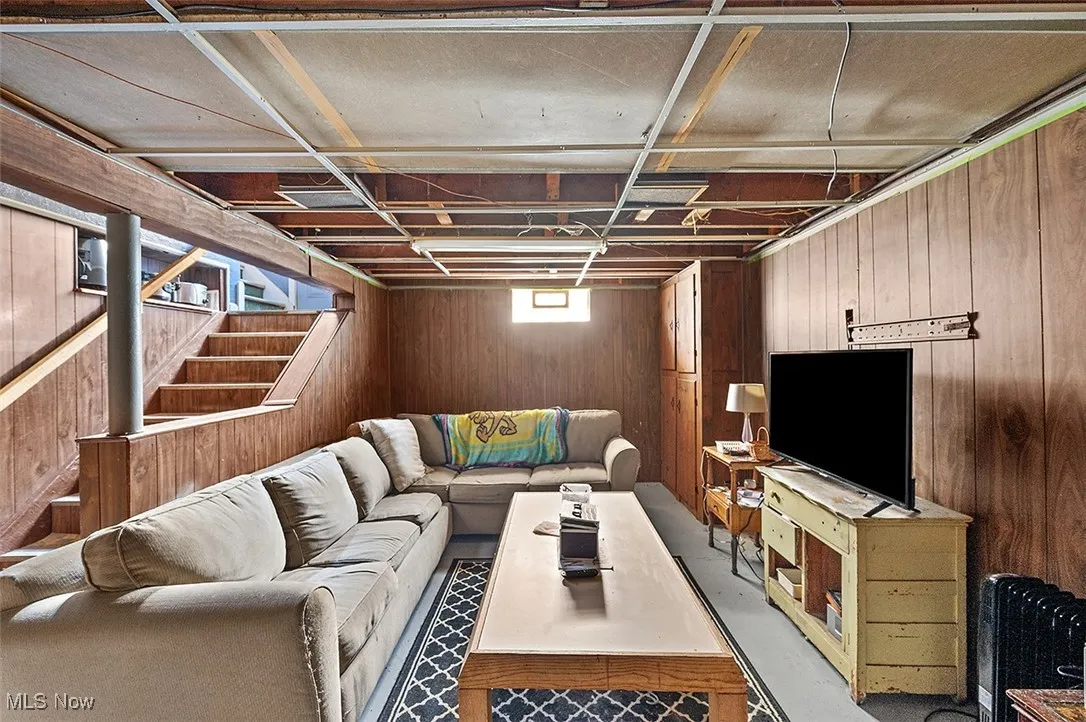 Living room featuring wood walls and stairway
