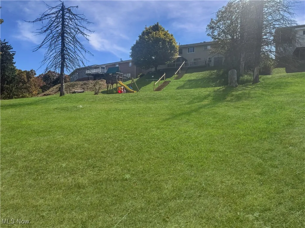 View of grassy yard featuring a playground