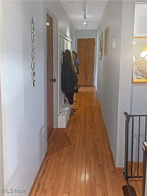 Hall featuring light wood finished floors and baseboards
