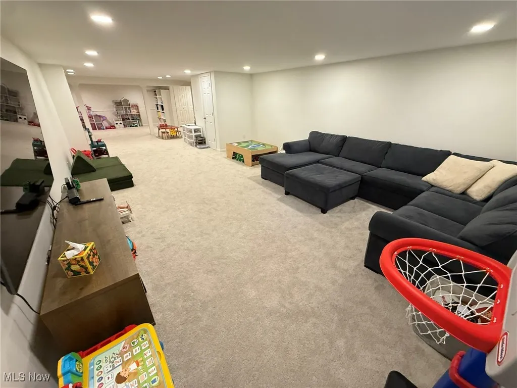 Carpeted living area with recessed lighting