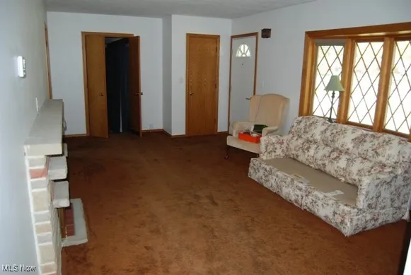 Carpeted living area featuring baseboards