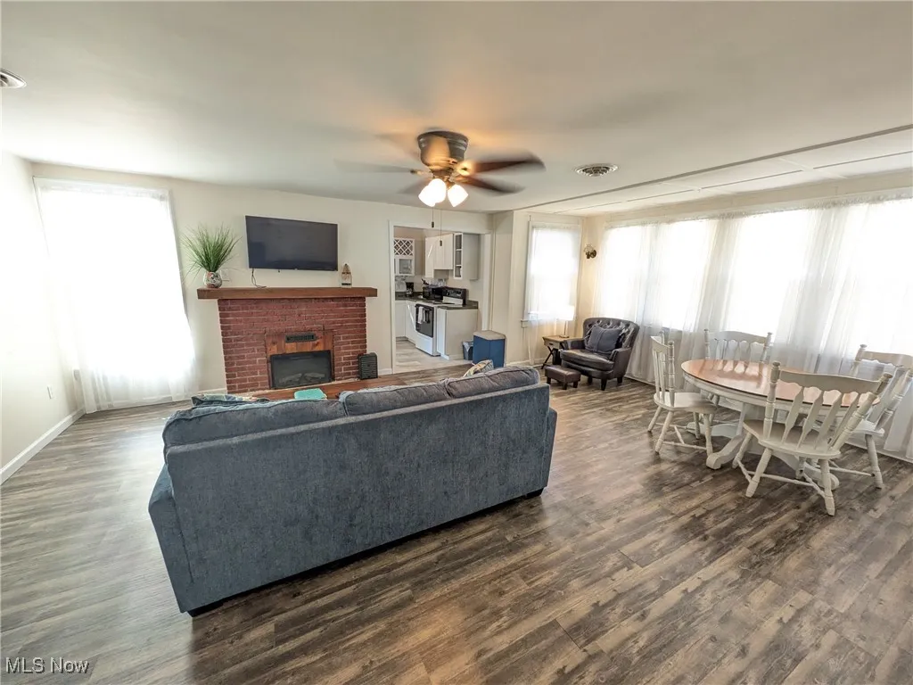 View from front door upon entry. Stairway to upstairs is immediately to left of front door. Eating area to right, entry to kitchen in center of opposite wall and fireplace to left.
