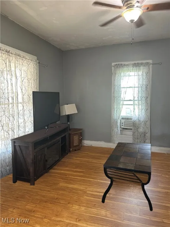 Living area featuring light wood-style flooring and ceiling fan