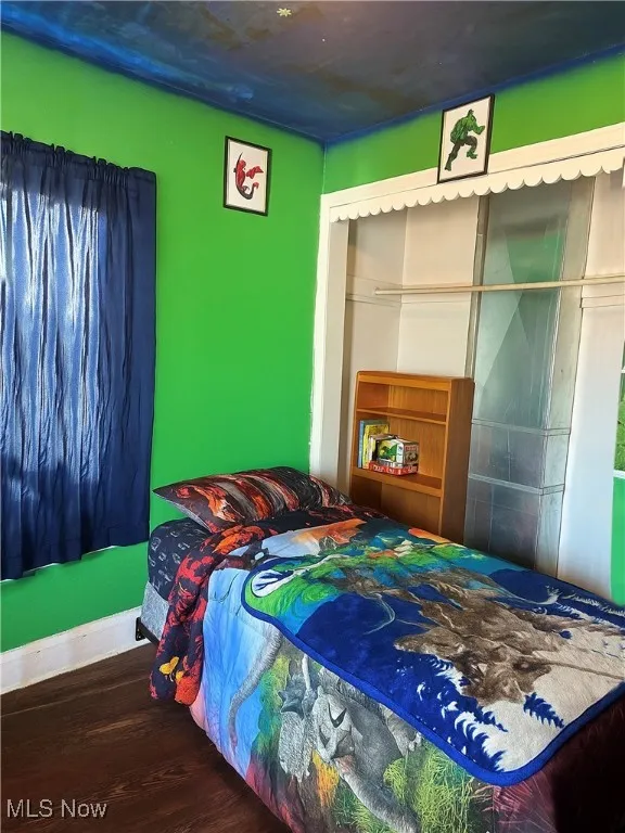 Bedroom featuring wood finished floors and baseboards
