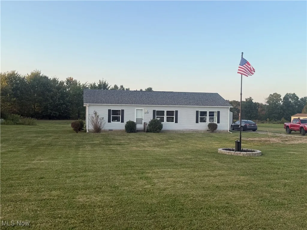 Ranch-style house featuring a front yard, roof with shingles, and crawl space