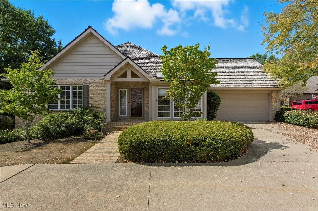 Ranch-style home featuring driveway, a garage, and brick siding