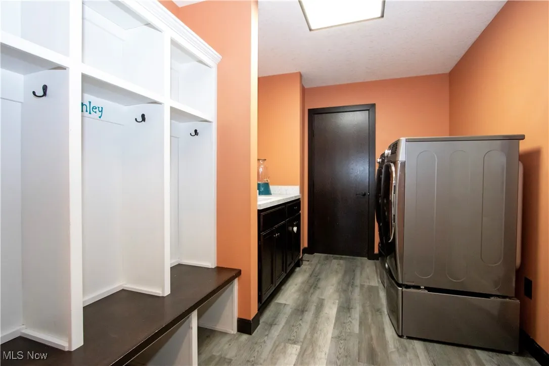Laundry area with light wood-style flooring and baseboards