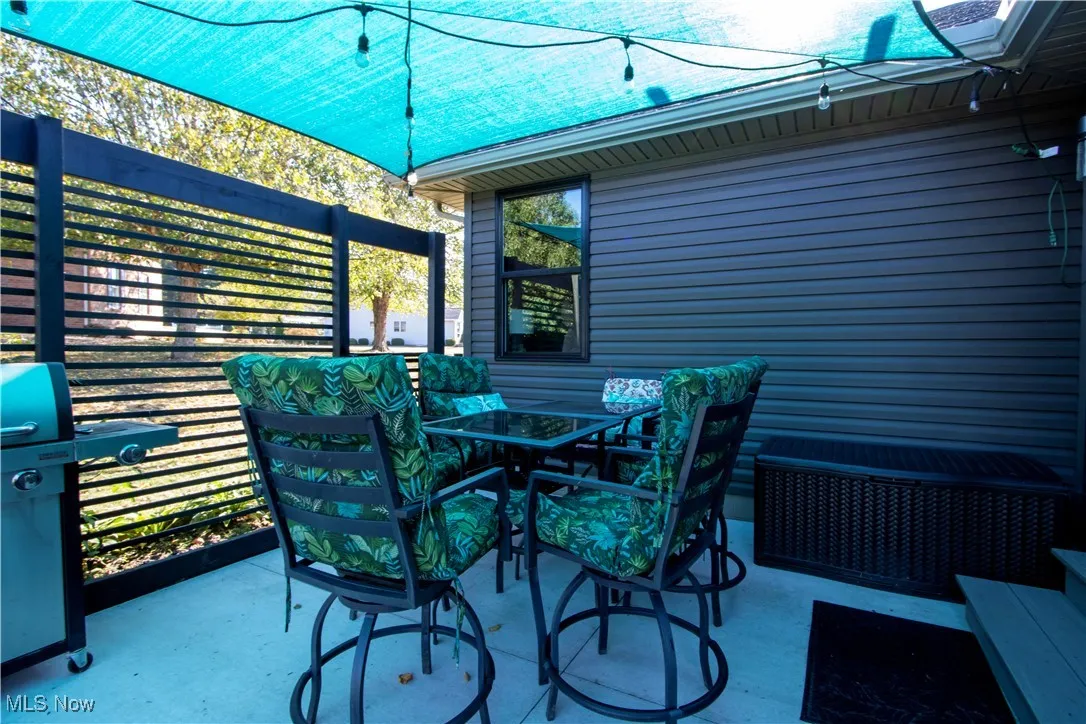 View of patio with outdoor dining area and a grill