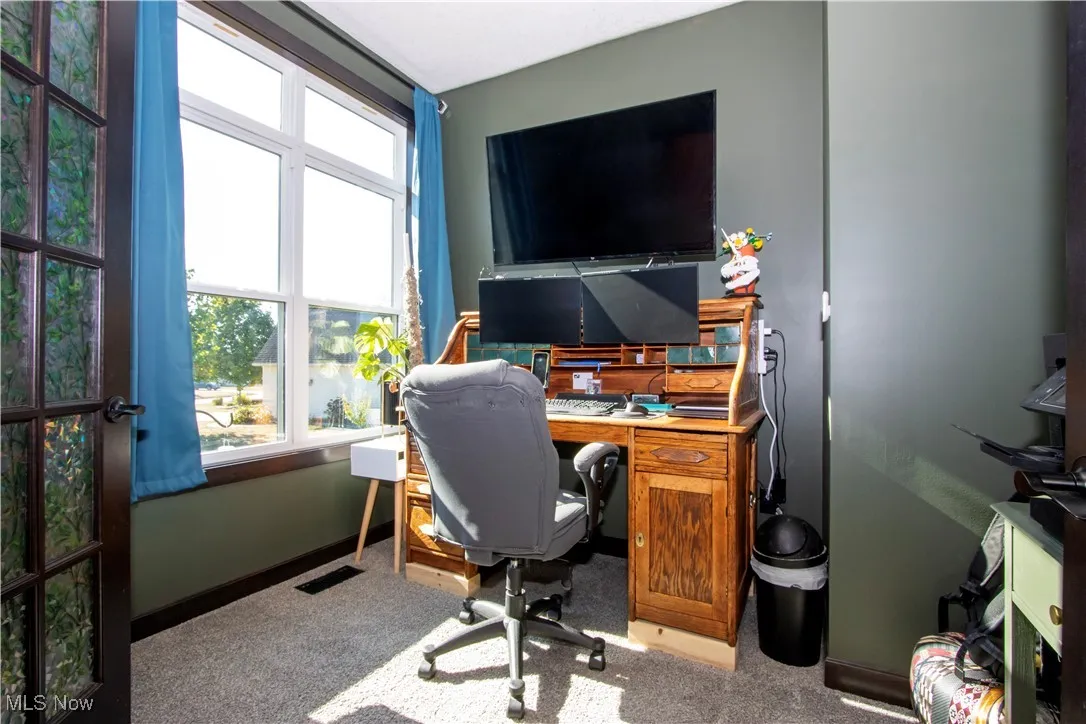 Office area featuring baseboards and carpet flooring