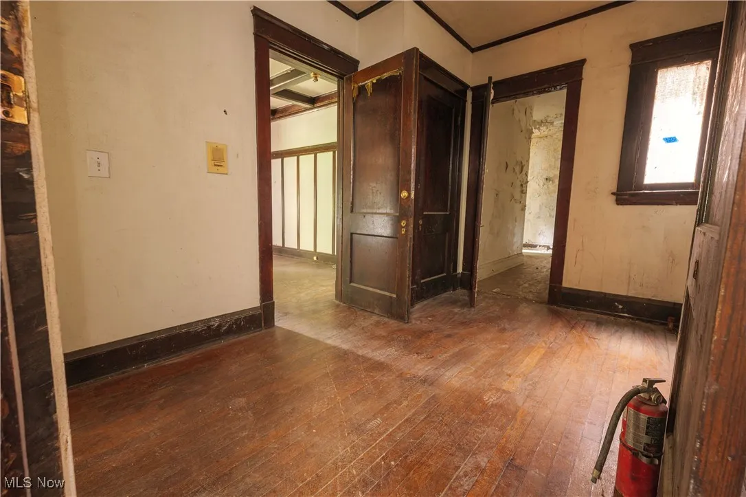 Empty room featuring dark wood finished floors and baseboards