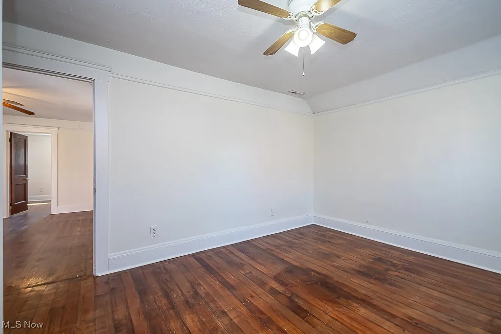 Spare room with a ceiling fan and dark wood finished floors