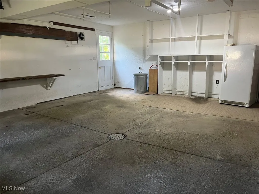 Garage has storage shelves and second refrigerator (stays)
