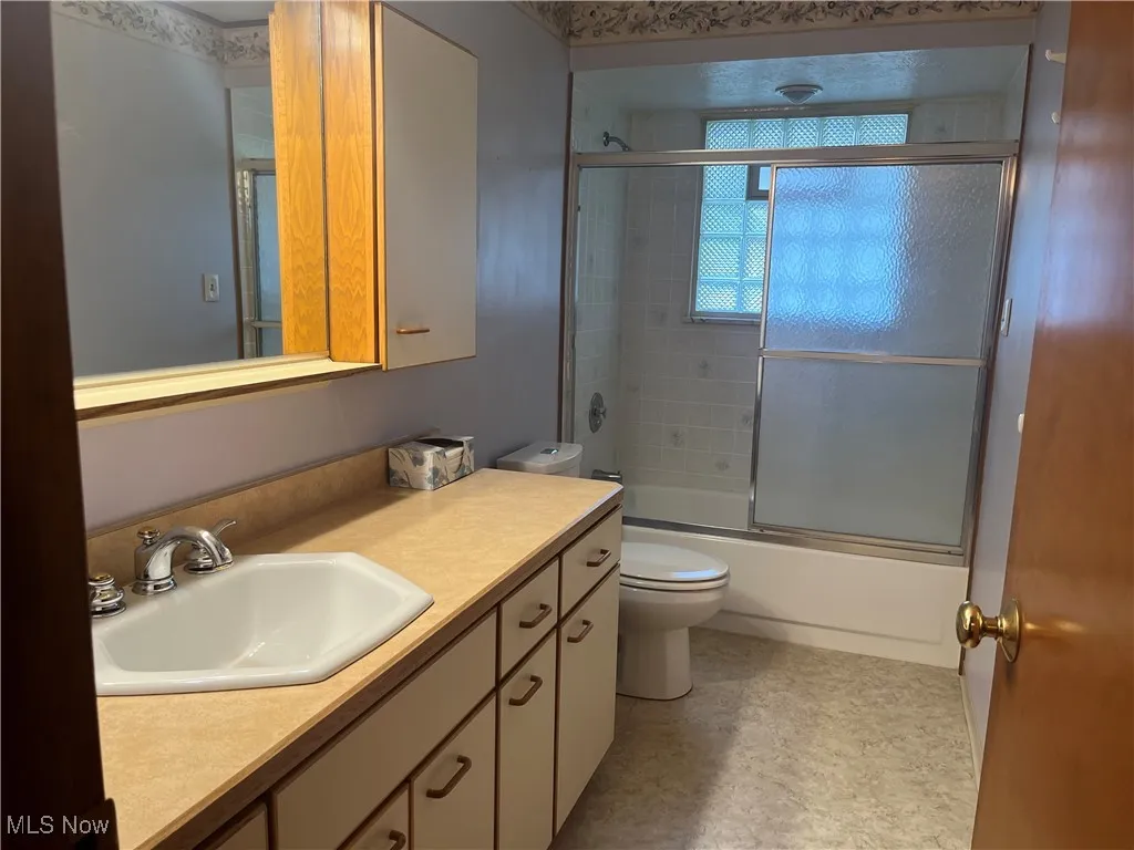 Upstairs Full Bathroom featuring shower/ bathtub combination with glass door and vanity