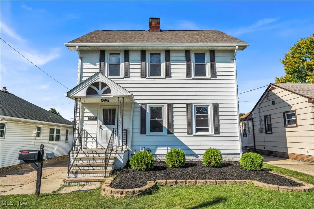 View of front of property with a chimney, roof with shingles, and a front yard