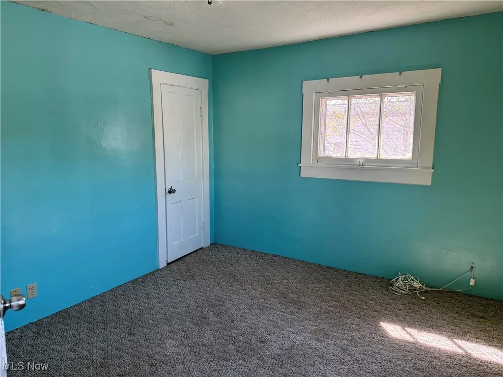 Carpeted empty room with a textured ceiling