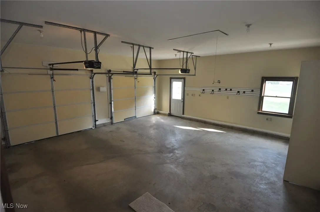 Garage with baseboards and garage door openers