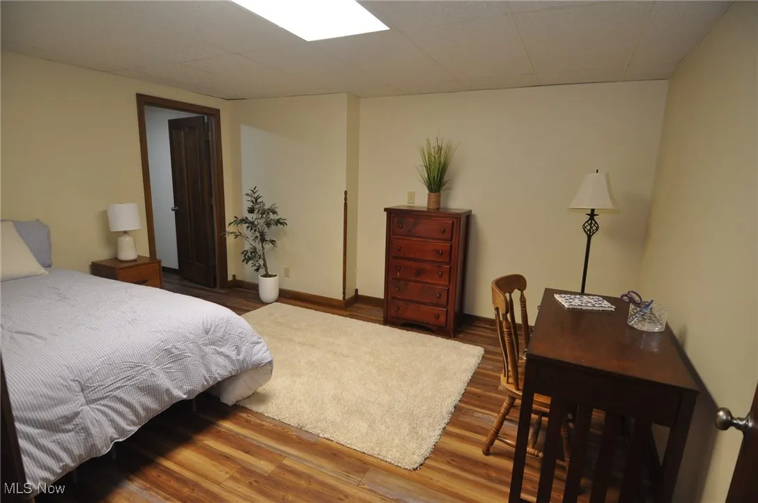 Lower level bonus bedroom/office/playroom with wood finished vinyl floors and a drop ceiling