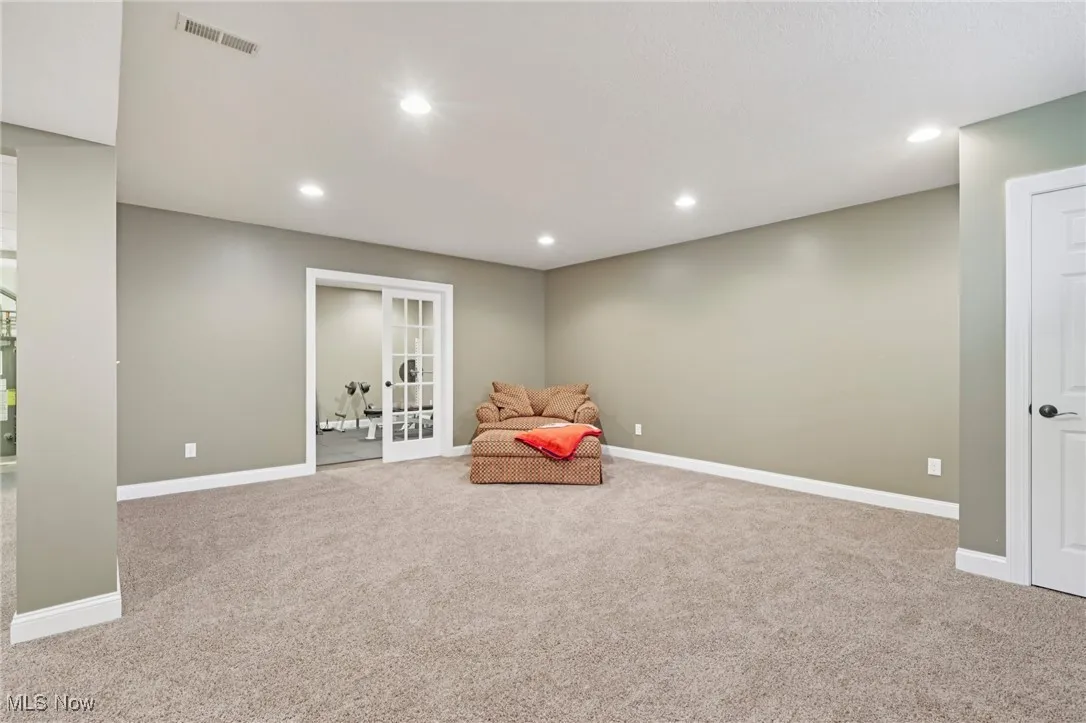 Unfurnished room with light colored carpet, recessed lighting, and french doors