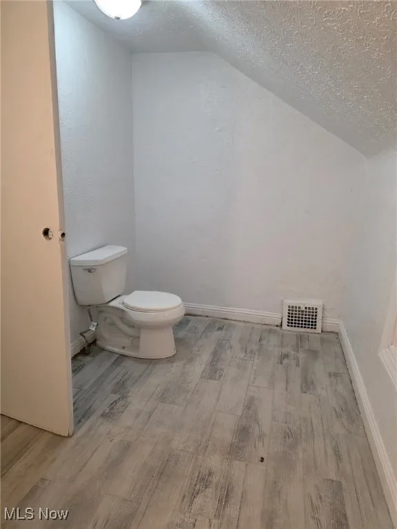 Bathroom featuring a textured ceiling and light wood-style flooring