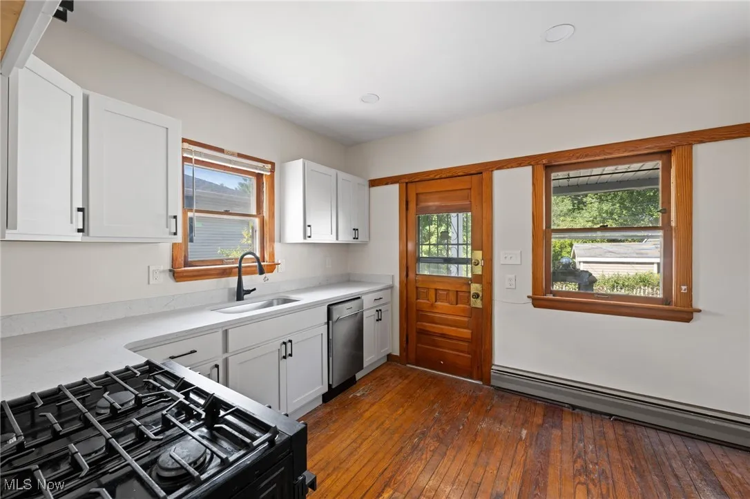 Kitchen with white cabinetry, healthy amount of natural light, and wood-style floors