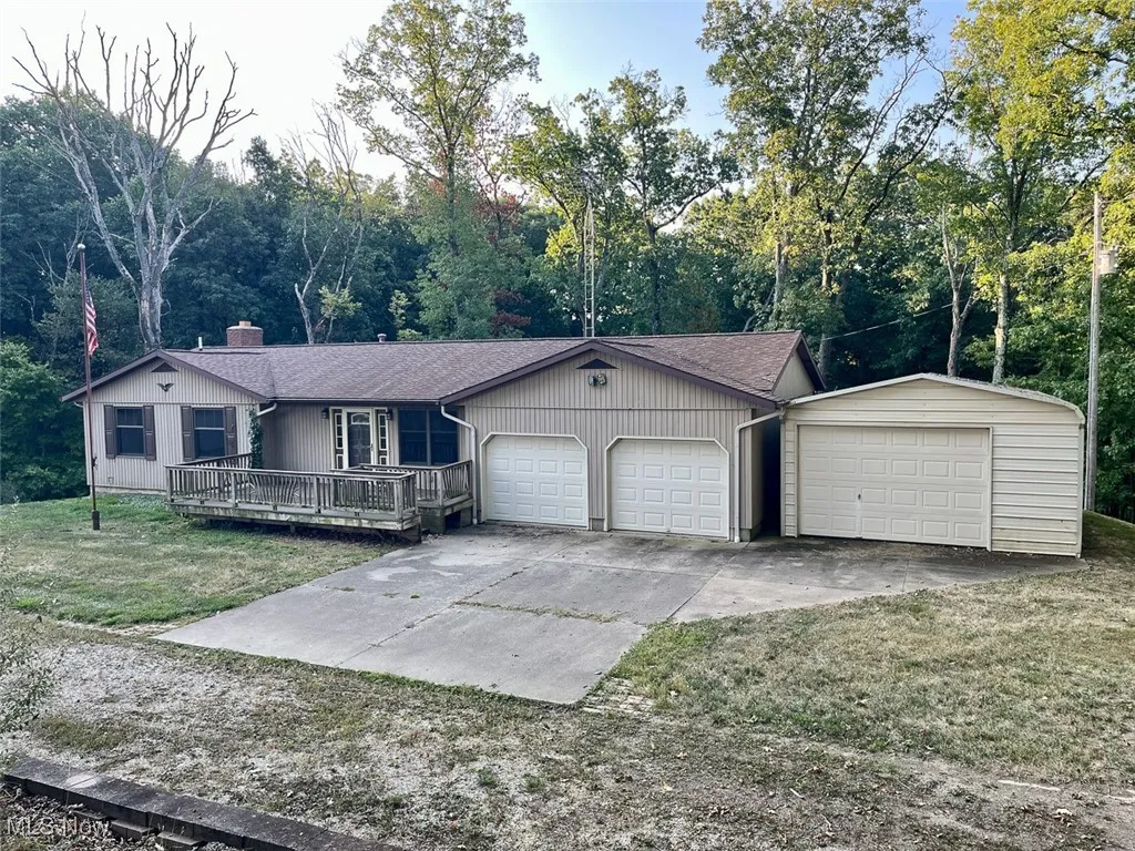 Single story home with roof with shingles, a front yard, a chimney, and driveway